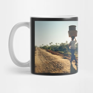 Woman Carrying Baskets on Head Walking in Burmese Countryside in Beautiful Morning Light Mug